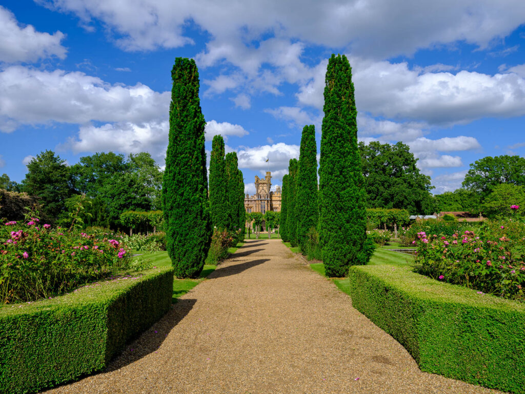 Knebworth House viewed down a path of poplar trees.