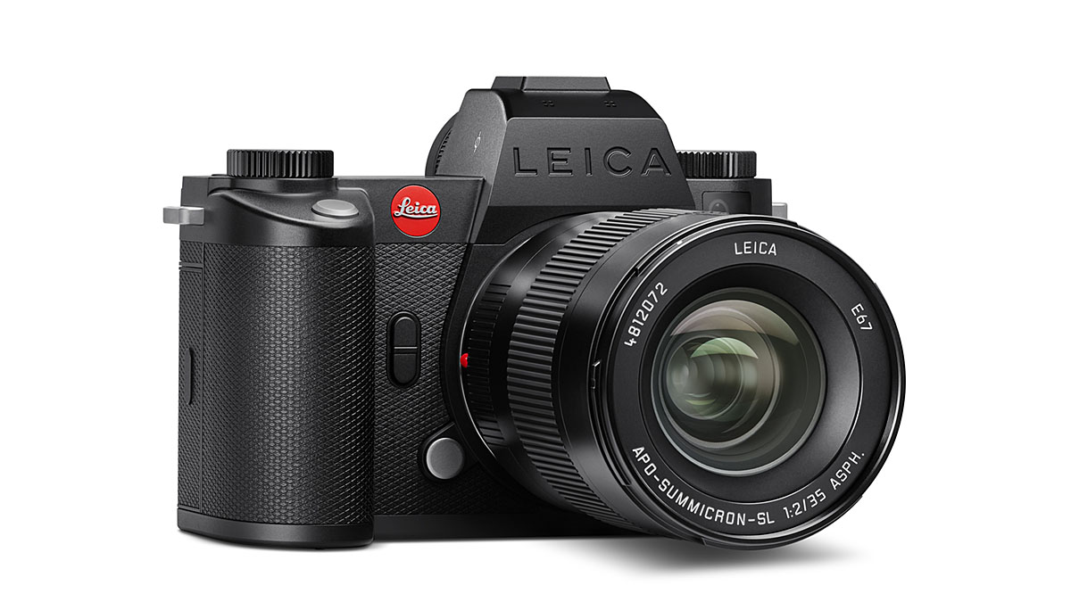Black Leica mirrorless camera with lens on a white background.
