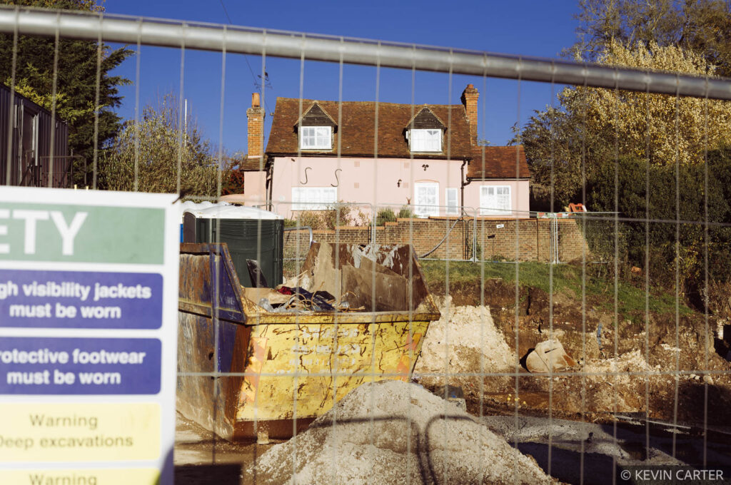 Building site showing a cottage in the background.